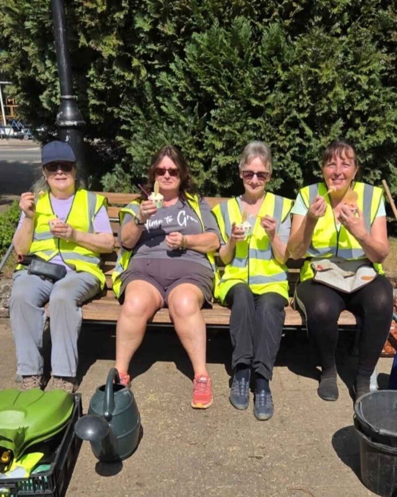 Woodhall Spa in Bloom volunteers enjoying a break together outdoors.