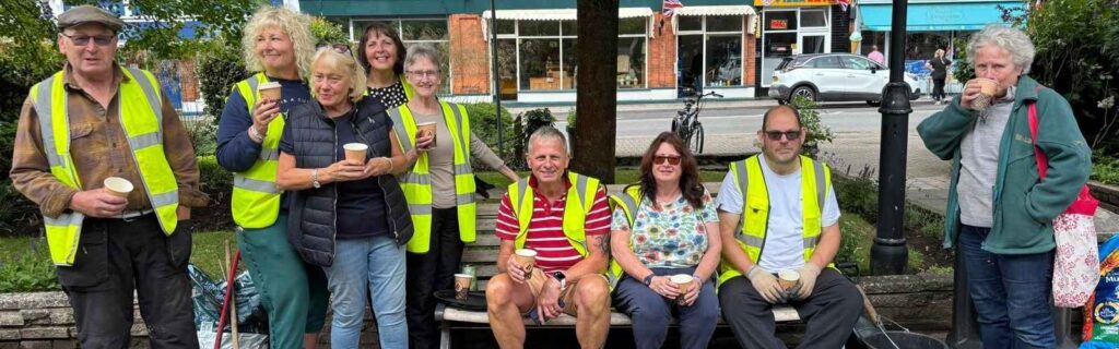 Woodhall Spa in Bloom volunteers together outside a village building.