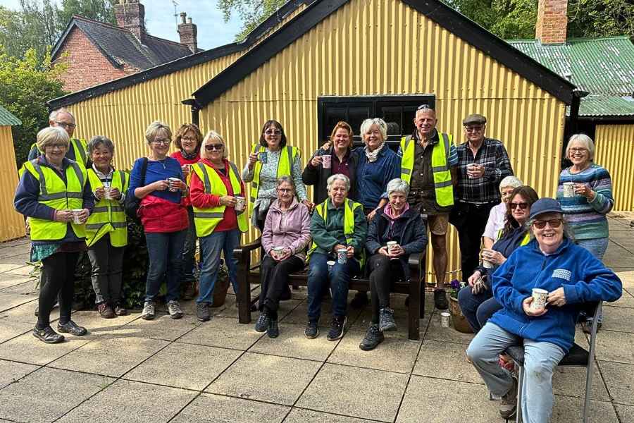 Woodhall Spa in Bloom volunteers gathered outside a garden building.